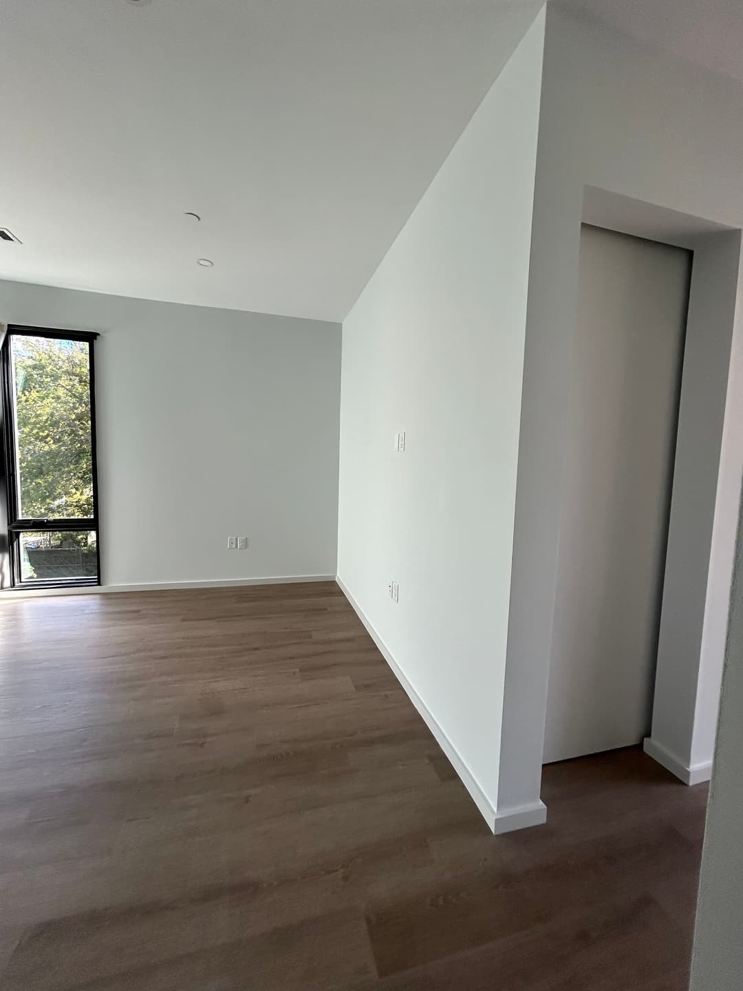Freshly painted white condo living space with new floors on Merritt Ave, Nashville